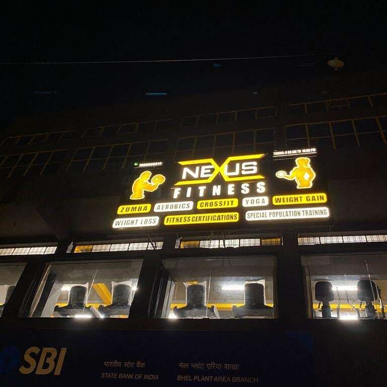 Lit Nexus Fitness sign above the SBI branch at night